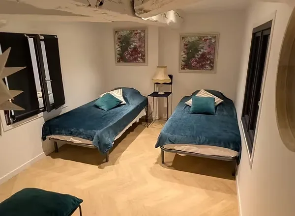 Chambre avec deux lits jumeaux 90 cm, draps bleus et poutres apparentes
