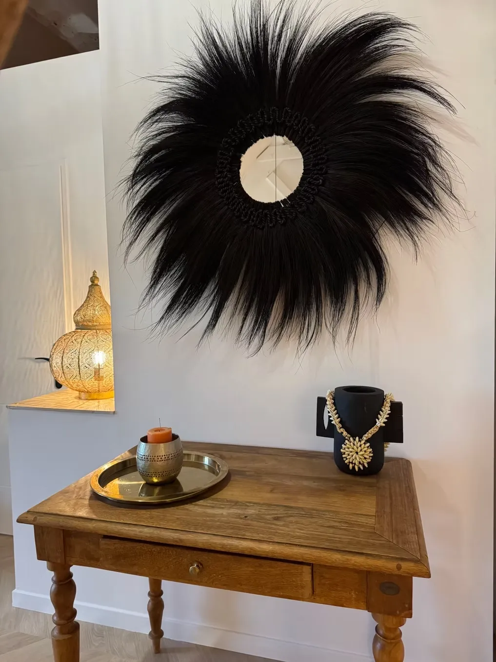 Détail déco : juju hat noir, lanterne dorée sculptée et console en bois ancien