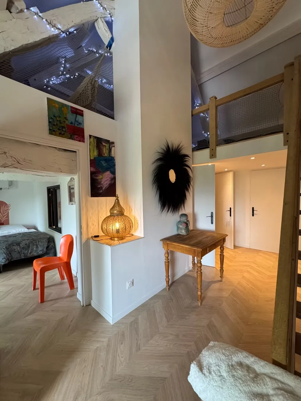 Couloir d'entrée avec parquet point de Hongrie, luminaires boho et décoration colorée