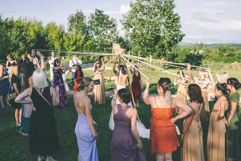 Invités participant à une animation de mariage avec des rubans dans le jardin
