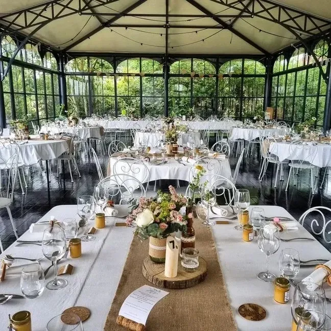 Vue d'ensemble de l'Orangerie dressée pour une réception champêtre, chemin de table en toile de jute
