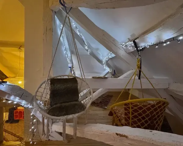 Coin relax en mezzanine avec chaises suspendues et guirlandes lumineuses étoilées