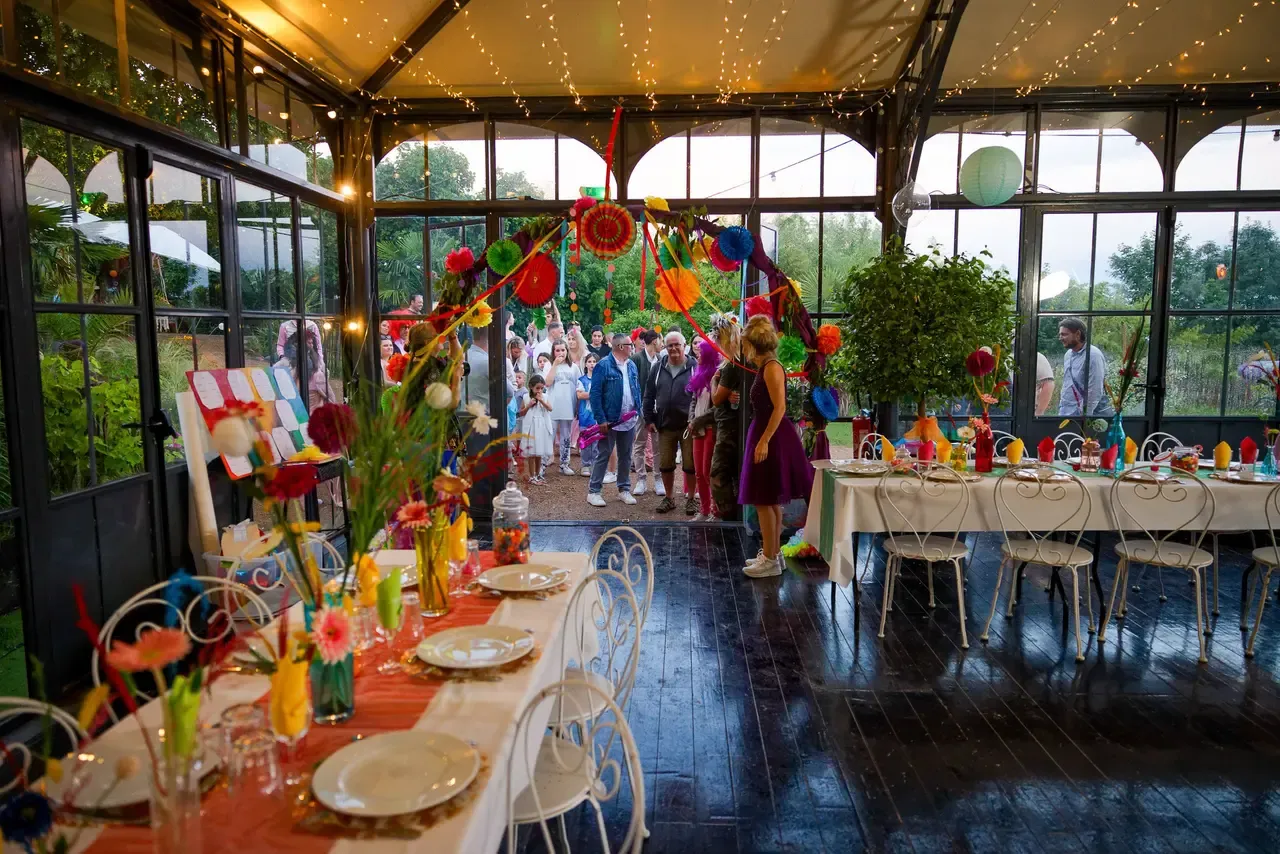 Table colorée dressée dans un espace vitré ouvert sur le jardin